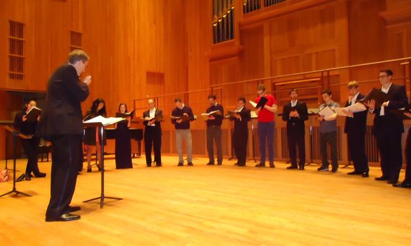 Director James John and Queens College Vocal Ensemble warming up for their final season performance.