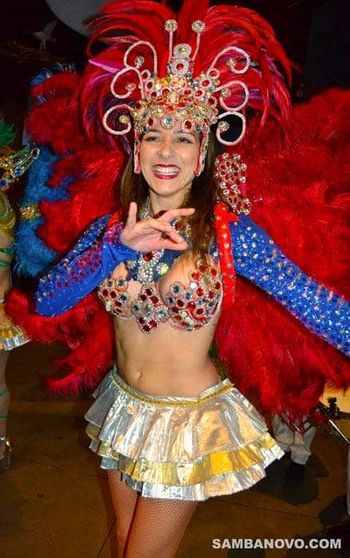 Hire Brazilian dancers like this beautiful dancer who is wearing a red & silver sequin outfit with blue sleeves and a skirt
