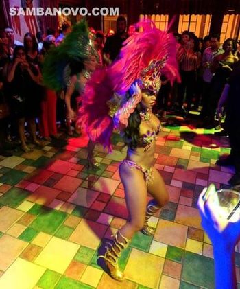 Carnival dancers for hire like this dancer who is dancing on a colorful dancer floor surrounded by guests at a private party
