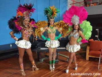 3 Brazilian carnival dancers in colorful feathered outfits with short skirts who will add glamour and excitement to the event
