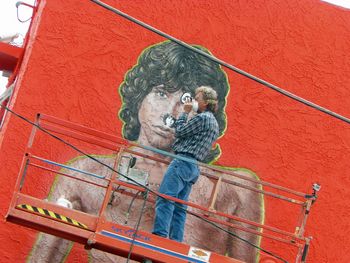 "Yep, That's Him" Artist Rip Cronk refreshes his famous mural of Jim Morrison, located on a beachside building at Venice Beach in the summer of 2012 while using Morrison’s famous “Lion Shoot” photo for reference. Venice Beach was the location of the re-meeting of Morrison and Manzarek in 1965 where “The Doors” were born.
