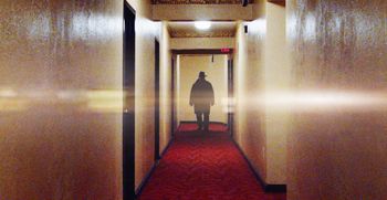 A stranger walks down apt corridor

