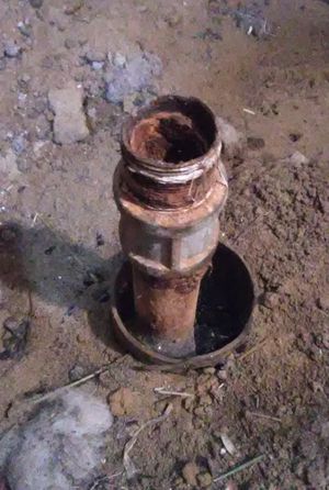 Photo of metal pipe in plastic tube in the ground