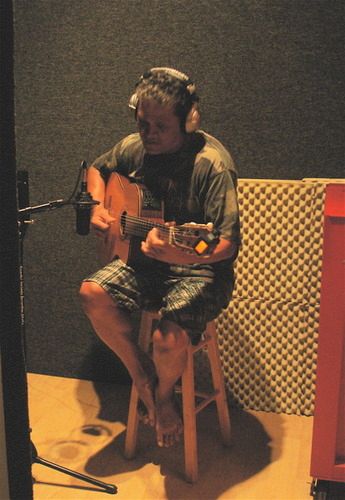 Ron Kuala'au concentrating while recording acoustic guitar
