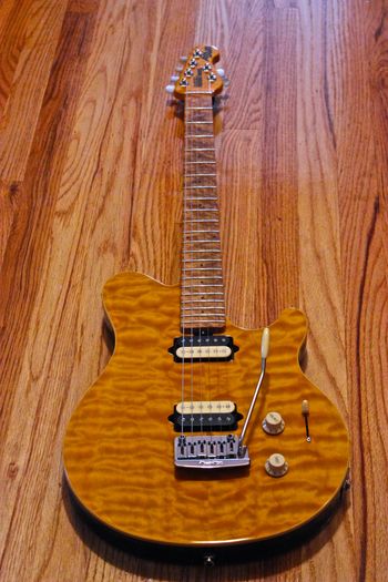 (10/15/2013) I always wanted one of these. It's a Music Man Axis Super Sport. It has a basswood body with a mahogany tone block in the middle and a bookmatched figured maple top. The neck is birdseye maple with a wax based finish. Two custom wound DiMarzio's with a 5-way selector. And the Music Man bridge with the locking turners is an awesome combo. The guitar also doubles as a sledgehammer because it's build is that solid.
