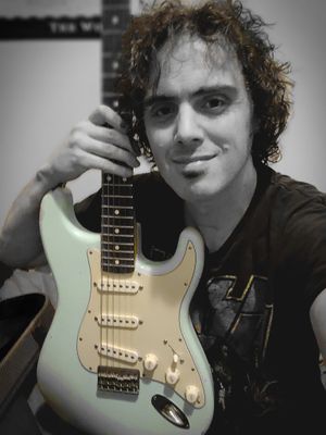 Roxx Hunter Looking into Camera holding light blue electric guitar