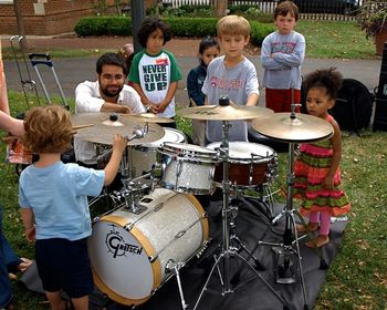 Aaron shows the kids his drumset.
